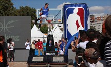Un miembro del Dunk Team se cuelga del aro en la zona NBA de Madrid