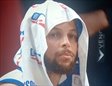 Curry con gesto serio se ve frustrado en la banda con toalla en la cabeza