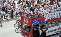 LeBron James (con gorra verde) saluda a los aficionados desde uno de los autobuses del desfile