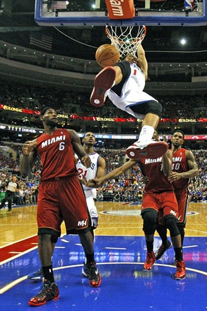Michael Carter-Williams se cuelga del aro ante la mirada de LeBron James